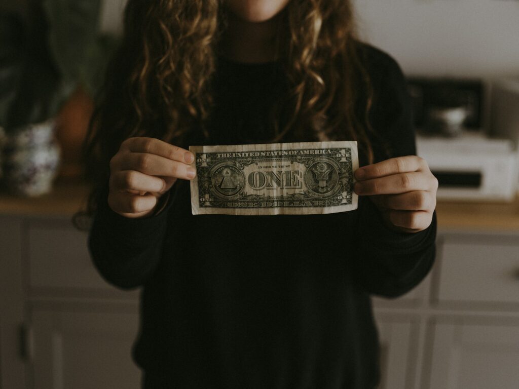 girl holding 1 U.S. dollar in reference to the blog post about making payments off of the ministays platform