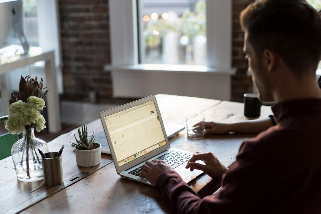 man operating laptop on top of table looking at MiniStays cookie policy